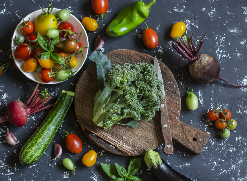 Fresh vegetables on dark background - broccoli, tomatoes, peppers, beets, eggplant, radish. Vegetarian table. Raw ingredients